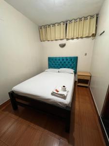 a bed with a blue headboard in a room at Hostal Las Vegas in Lima