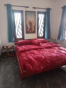 una camera da letto con un grande letto con lenzuola rosse e finestre di Maison neuve et moderne à Vientiane 