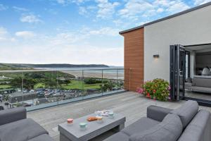 a balcony with couches and a view of the ocean at Shore End - W1 in Woolacombe