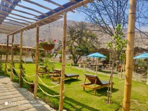 un giardino con amache, tavoli e ombrelloni di Hotel Nuestro Amo a Sayán