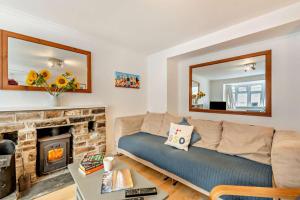 un soggiorno con divano e camino di Hillcrest Cottage a Little Haven