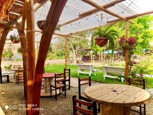 un tavolo e sedie in legno sotto un pergolato di legno di Hotel Nuestro Amo a Sayán