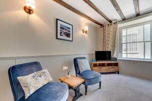 a living room with a chair and a tv at Cosy Nook in Appledore
