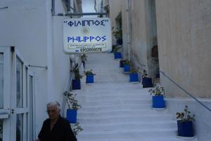 a man walking down a stairway with blue potted plants at Filippos in Agios Kirykos +2 photos