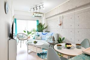 a living room with a couch and tables and chairs at アロハベース in Takamatsu