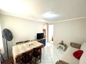 a living room with a table and a couch at Apartamento Mobiliado em Limeira in Limeira
