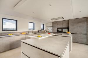 a large kitchen with stainless steel counter tops and windows at Siop Penrallt- Rhiw in Bottwnog