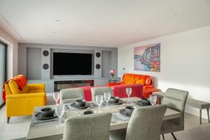 a living room with a table and chairs and a television at Siop Penrallt- Rhiw in Bottwnog