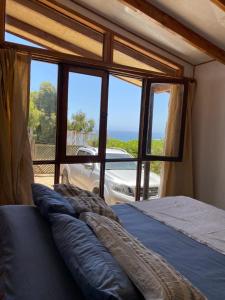 a bed in a room with a large window at Malibu Hostal Boutique in Maitencillo