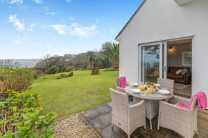 Carbis BayにあるRosen 7 Godrevy Courtの芝生の上にテーブルと椅子付きのパティオ