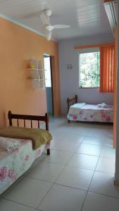 a bedroom with two beds and a window at Recanto verde pousada in Angra dos Reis