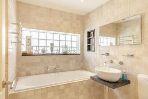 a bathroom with a tub and a sink and a window at Higher Close in Mawgan Porth +25 photos