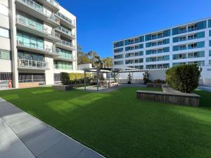 einem grünen Rasen vor einem Gebäude in der Unterkunft Waterfront Premium Apartment in central Geelong in Geelong