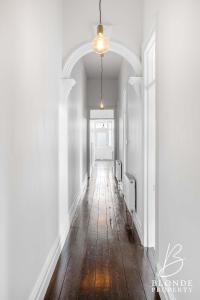 an empty hallway with white walls and a wooden floor at The Alto in Ballarat