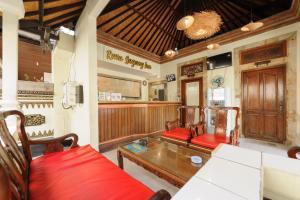 a dining room with red chairs and a table at Urbanview Hotel Rasa Sayang Inn Tanjung Benoa Bali in Nusa Dua