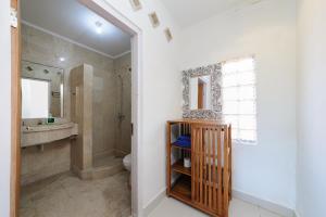 a bathroom with a sink and a toilet and a mirror at Urbanview Hotel Rasa Sayang Inn Tanjung Benoa Bali in Nusa Dua +28 photos
