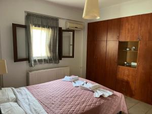 a bedroom with a bed with two towels on it at Όμορφο διαμέρισμα με εκπληκτική θέα in Menídion