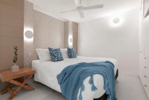 a bedroom with a bed with a blue blanket on it at 71 Hastings - Beachfront in Noosa Heads