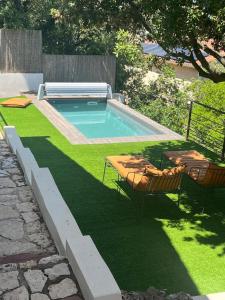 a swimming pool with two chairs on the grass at HorizSky Villa, 6p, 3BR, pool, WiFi in Saint-Raphaël