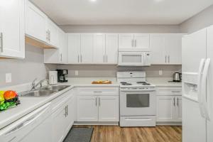 a white kitchen with white appliances and white cabinets at Cute & Cozy - Minutes from Downtown & BNA in Nashville +16 photos