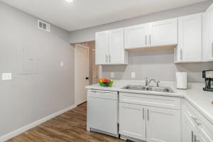 a kitchen with white cabinets and a sink at Cute & Cozy - Minutes from Downtown & BNA in Nashville