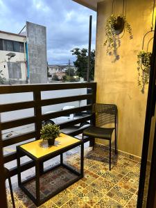 einen Tisch und einen Stuhl auf dem Balkon in der Unterkunft Departamento Moderno con balcón y piscina climatizada in Rosarito Beach