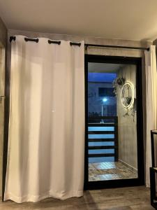 einem weißen Vorhang vor einer Glasschiebetür in der Unterkunft Departamento Moderno con balcón y piscina climatizada in Rosarito Beach + 16 Fotos