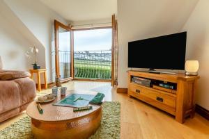 a living room with a large flat screen tv at Marazion Sail Loft in Marazion
