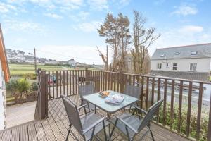 a patio with a table and chairs on a balcony at Marazion Sail Loft in Marazion