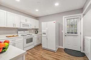 a kitchen with white cabinets and a white refrigerator at Cute & Cozy - Minutes from Downtown & BNA in Nashville