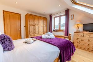 a bedroom with a large bed with a purple blanket at Marazion Sail Loft in Marazion
