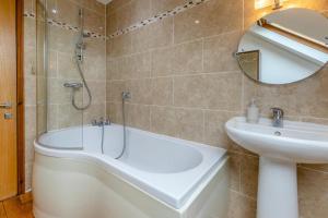 a bathroom with a bath tub and a sink at Marazion Sail Loft in Marazion +16 photos