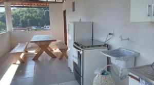 a kitchen with a stove and a table in it at Recanto verde pousada in Angra dos Reis +20 photos