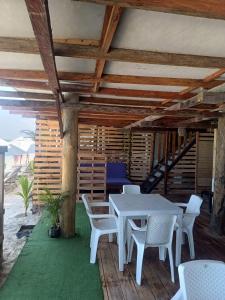 a patio with a table and chairs and a staircase at Cabañas Palos Locos in Baru