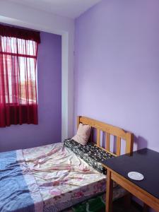 a small bedroom with a bed and a table at Hospedaje in Aguaytía
