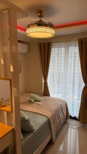 a bedroom with a bed with a chandelier and a window at The Horizons Place in Lapu Lapu City +24 photos