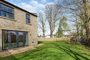 een stenen huis met een tuin met een hek bij Charter Gardens Cottage in Kirkby Stephen