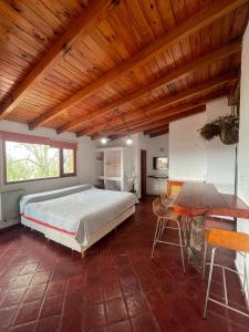 a bedroom with a bed and a wooden ceiling at Cabañas Terrazas del Sol in Villa Carlos Paz
