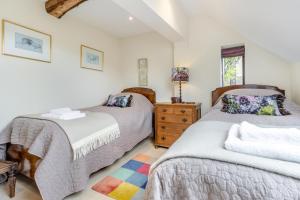 a bedroom with two beds and a dresser at The Holt Barn in Tong