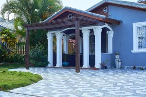 a blue house with a pergola in front of it at Pergola House 1 or 2 bedrooms in Montego Bay