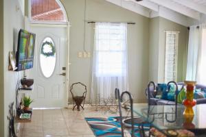a living room with a glass table and a window at Pergola House 1 or 2 bedrooms in Montego Bay