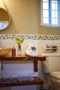 a bathroom with a shelf with towels and a toilet at Pergola House 1 or 2 bedrooms in Montego Bay +11 photos