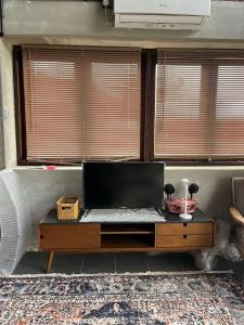 a desk with a laptop on it in a room with windows at 1 Unit 'Rumah Singgah' Minimalist Concept House in Kg Mangkok, Penarik Terengganu in Kampong Mangkok
