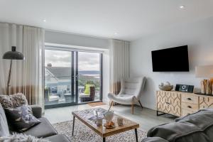 Una sala de estar con un sofá y un televisor. en Sea Sand - W12, en Woolacombe