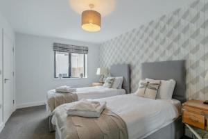 Un dormitorio con dos camas y una ventana. en Sea Sand - W12, en Woolacombe 25 fotos más