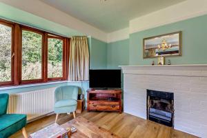 a living room with a fireplace and a tv at Willow House - Dymchurch in Dymchurch