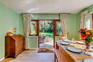a dining room with a long table with plates and glasses at Willow House - Dymchurch in Dymchurch