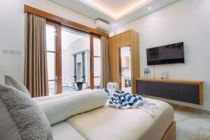 ein Wohnzimmer mit Sofa und Fernseher in der Unterkunft The Lavana Sahadewa Villa Kuta Sunset in Legian