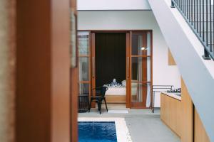 ein Haus mit einem Pool und einem Schlafzimmer in der Unterkunft The Lavana Sahadewa Villa Kuta Sunset in Legian