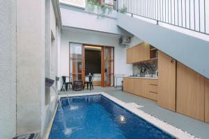 ein Haus mit einem Swimmingpool in der Mitte eines Gebäudes in der Unterkunft The Lavana Sahadewa Villa Kuta Sunset in Legian